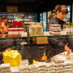 Im Maison du Beurre können Kunden dem Schlagen der Butter zuschauen.  Verkauft werden verschiedene auch aromatisierte Buttersorten / © Foto: Georg Berg