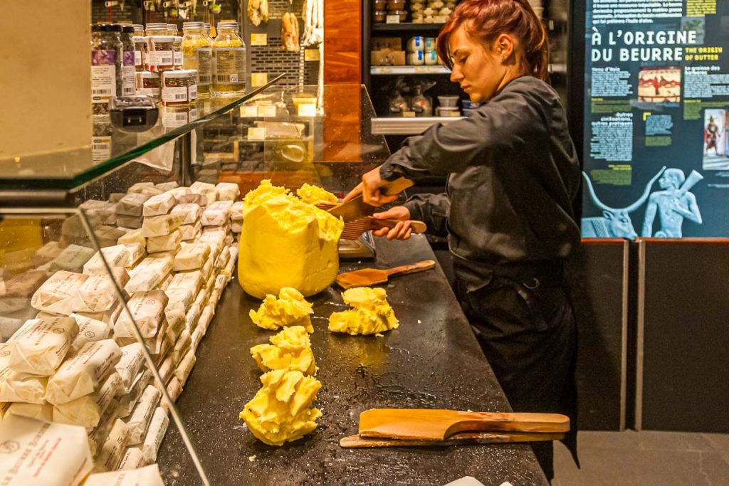 Im Maison du Beurre in Saint Malo teilt die Verkäuferin aus einem Butterblock Stücke von 125 g ab / © Foto: Georg Berg