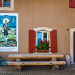 Absinth in Frankreich und der Schweiz. In Motiers im Schweizer Kanton Neuchâtel befindet sich das unterhaltsame Absinthmuseum, und an einigen Häuserwänden der Stadt erinnern historische Plakate an die Zeit der Prohibition / © Foto: Georg Berg
