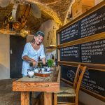 Gabriella in der Küche. Geradezu galaktisch schweben große Töpfe und Pfannen am Kellerfirmament / © Foto: Georg Berg