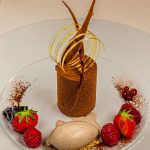 Die wunderschönen Desserts wie dieser Schockokuchen mit Timut Pfeffer an Tonka Eis werden von Florent Jestin dekoriert / © Foto: Georg Berg