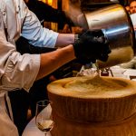 Ein ausgehöhlter Parmesanlaib wird mit Risotto gefüllt / © Foto: Georg Berg