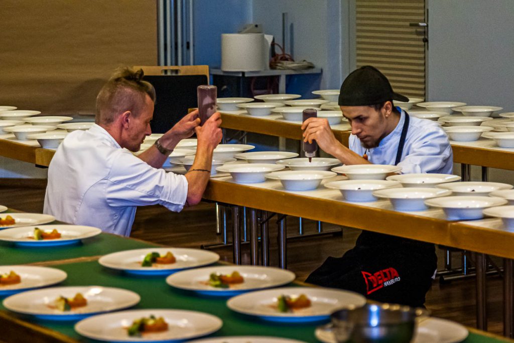 Zwei Köche aus dem Team von Michelin Star Chef Marco Müller dressieren die Teller auf dem Schleswig-Holstein-Gourmet-Festival in Sankt Peter-Ording / © Foto: Georg Berg