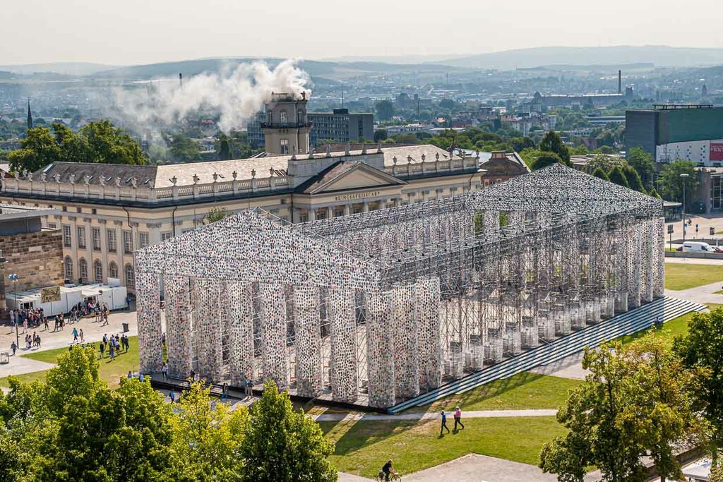 Parthenon of Books, by Argentine artist Marta Minujin at documenta 14 in Kassel. Every day the construction, which in its dimensions is a replica of the temple on the Acropolis, became more massive and filled with more books. In the background, the installation "Expiration Movement" smokes in the Zwehrenturm / © Photo: Georg Berg