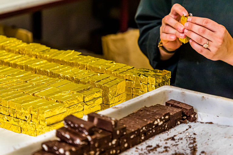 Handmade, the bestseller of the chocolate manufactory Frigoulette is wrapped in golden paper. The Malakoff praline from Chocolaterie Frigoulette is available throughout France and is especially popular at Christmas. Malakoff is one of those sliced chocolates that do not have an additional wrapper around the center. The roasted hazelnuts give the praline a crunchy texture / © Photo: Georg Berg