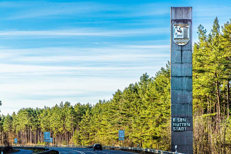 Stele with coat of arms of Eisenhüttenstadt at the entrance to the town. Eisenhüttenstadt is one of the largest area monuments in Germany / © Photo: Georg Berg
