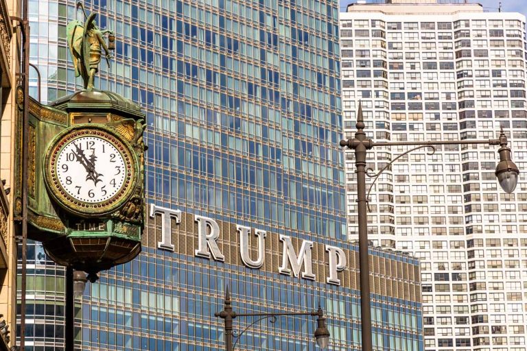 Trump Tower Chicago on the DuSable Bridge and opposite an old street clock with the time display "Five to twelve" / © Photo: Georg Berg