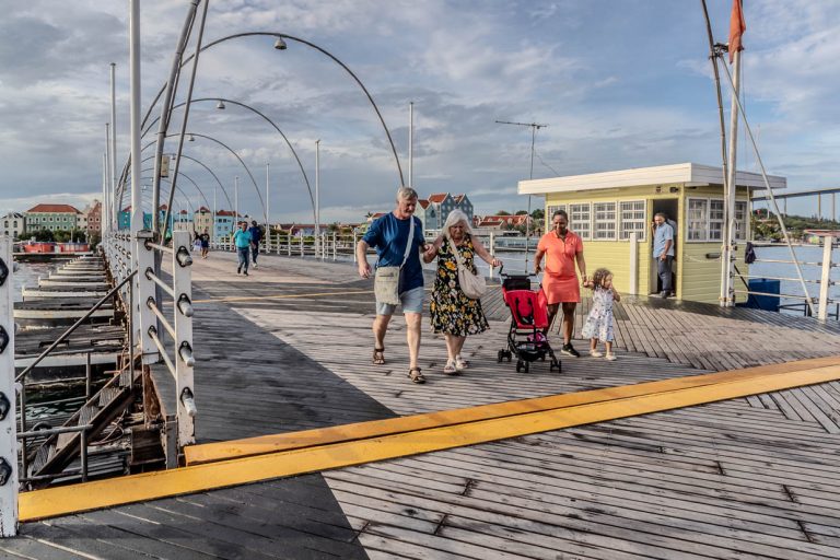 The Queen Emma Bridge slowly starts to move sideways. Pedestrians have to decide whether the "Swinging Old Lady" should take them on the 20-minute swing across the Sint Annabaai or whether they would rather go ashore / © Photo: Georg Berg