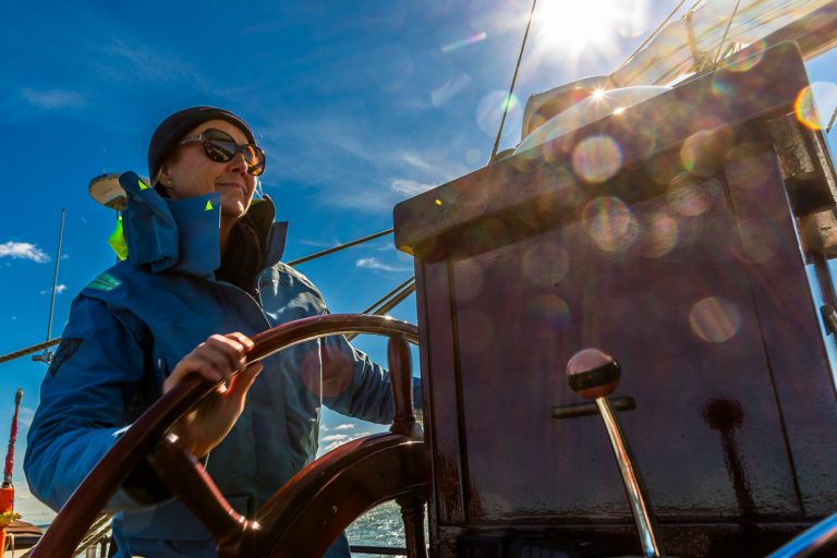 Captain Jane Bothe steers the Weisse Düne, a Dutch flat-bottomed ship, through the Achterwasser, the lagoon of the Peene River, which flows into the Baltic Sea. The ship departs several times a week from Neppermin, Wolgast or Karlshagen for trips through the Achterwasser / © Photo: Georg Berg