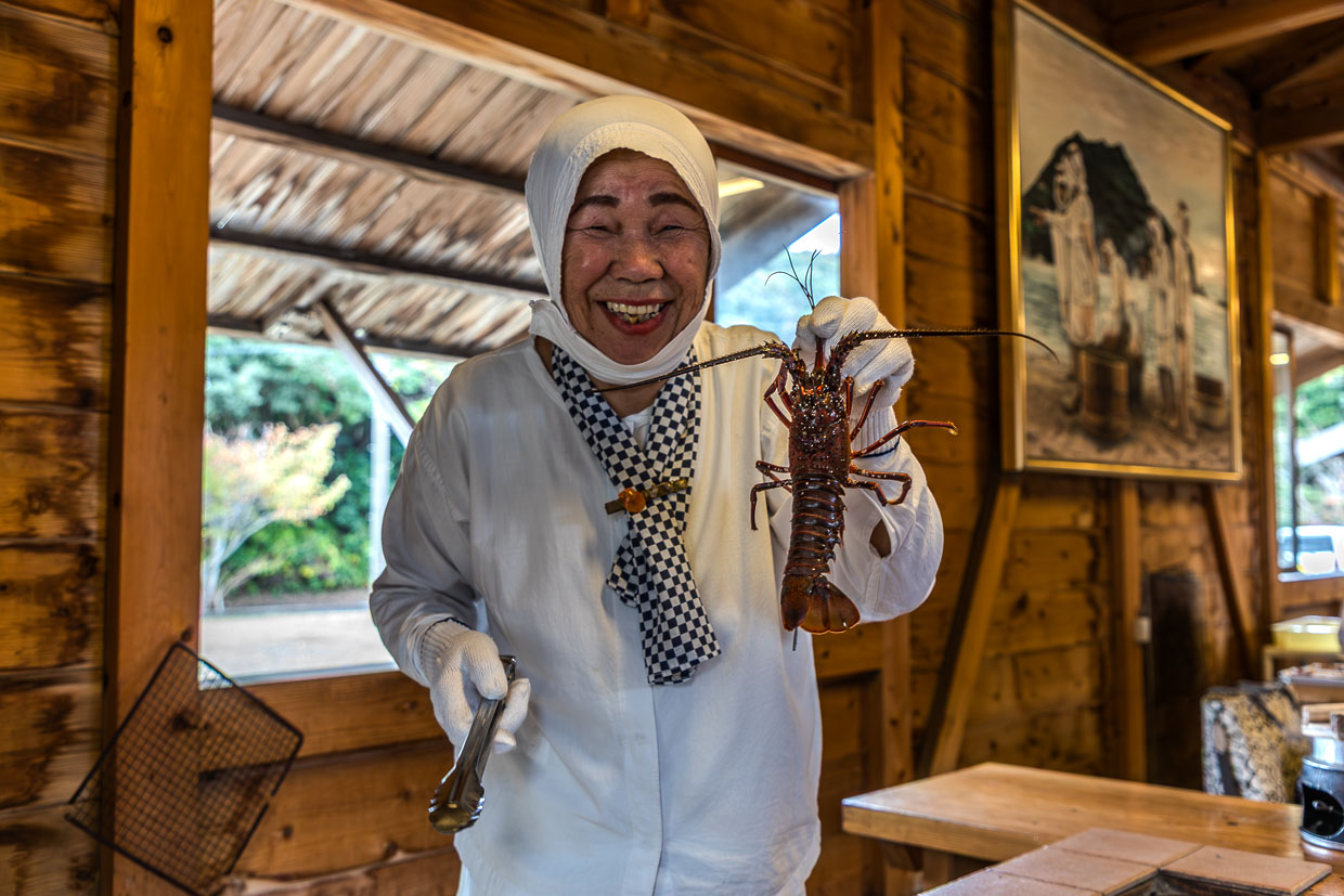 Frau präsentiert Hummer in einem Restaurant in Shima, Japan
